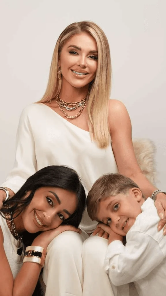 A mother with her two children against a warm neutral studio backdrop